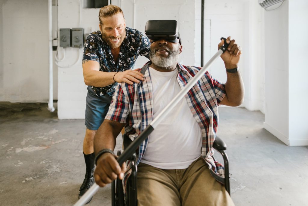 a-man-trying-to-help-an-old-man-use-an-assistive-technology
